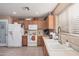 Bright kitchen with white appliances, tile flooring, and light wood cabinetry at 16424 W Cottonwood St, Surprise, AZ 85388