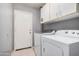 Functional laundry room with a washer, dryer, and storage cabinets above at 16424 W Cottonwood St, Surprise, AZ 85388