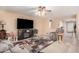 Cozy living room featuring a ceiling fan, a large TV, comfortable seating, and stylish décor at 16424 W Cottonwood St, Surprise, AZ 85388