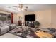 Comfortable living room with a ceiling fan, large TV, comfortable seating, and a stylish area rug at 16424 W Cottonwood St, Surprise, AZ 85388