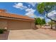 Exterior view of a two-car garage with a concrete driveway and desert landscaping against a blue sky at 1658 N Sierra Vista Dr, Tempe, AZ 85288