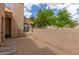 A fenced patio with brick pavers, an exterior door, and green trees against a blue sky at 1658 N Sierra Vista Dr, Tempe, AZ 85288