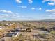 Aerial view of property with a house, sheds, desert landscaping, and surrounded by desert foliage at 16643 W Quail Run Rd, Surprise, AZ 85378