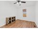 Bright bedroom showcasing wood-look floors, ceiling fan, a window, and two storage cubes at 16643 W Quail Run Rd, Surprise, AZ 85378