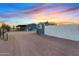 Wide shot of the exterior of this home with a shed, surrounded by desert landscaping at sunset at 16643 W Quail Run Rd, Surprise, AZ 85378