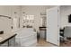 Bright main bathroom featuring a soaking tub, a large mirror, and neutral colors at 16643 W Quail Run Rd, Surprise, AZ 85378