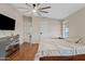 Bright main bedroom featuring a ceiling fan, wood floors, and a large dresser at 16643 W Quail Run Rd, Surprise, AZ 85378