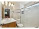 Bathroom with marble-look tile, glass shower door, toilet, and a vanity with sink and modern fixtures at 16729 N 157Th Ave, Surprise, AZ 85374