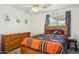 Comfortable bedroom with a wooden bed frame, dresser, and a bright window, styled with Denver Broncos comforter at 16729 N 157Th Ave, Surprise, AZ 85374