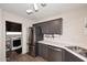Galley-style kitchen with stainless steel appliances, gray cabinets and a laundry area at 17606 N 17Th Pl # 1115, Phoenix, AZ 85022