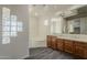 Bathroom featuring double sinks, a soaking tub, and a glass block accent wall at 17790 N 66Th Ln, Glendale, AZ 85308