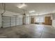 Large garage with multiple doors, overhead lighting, and built-in cabinets for organized storage at 17790 N 66Th Ln, Glendale, AZ 85308