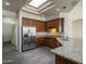 Open kitchen features stainless steel appliances, gray countertops, and wood cabinetry for a modern appeal at 17790 N 66Th Ln, Glendale, AZ 85308