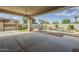 Spacious covered patio with a view of the sparkling pool, rock waterfall, and lush, landscaped backyard at 17790 N 66Th Ln, Glendale, AZ 85308