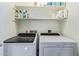 Bright laundry room with a washer, dryer, and shelving at 18725 N 92Nd Dr, Peoria, AZ 85382