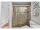 Modern tiled shower with wood accents, pebble floor, and seating at 18725 N 92Nd Dr, Peoria, AZ 85382