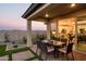 Back patio with a dining table, outdoor seating area, modern landscaping, and a sliding glass door at 19022 W Rose Ln, Waddell, AZ 85355