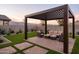 Inviting backyard patio featuring a modern pergola, stylish seating, artificial turf, and gravel landscaping at 19022 W Rose Ln, Waddell, AZ 85355