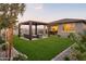 Aerial backyard view with a covered patio, modern pergola, manicured lawn, gravel landscaping, and privacy fencing at 19022 W Rose Ln, Waddell, AZ 85355