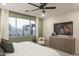 Bright bedroom boasts a large window, ceiling fan, and a dresser with a TV at 19022 W Rose Ln, Waddell, AZ 85355
