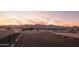 New community featuring a playground and sidewalks with mountain views in background at sunset at 19022 W Rose Ln, Waddell, AZ 85355