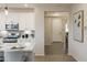 Modern kitchen with stainless steel appliances, white cabinets, and an open view to the entryway at 19022 W Rose Ln, Waddell, AZ 85355