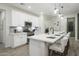 Bright kitchen showcasing a large island with seating, stainless steel appliances, and stylish pendant lights at 19022 W Rose Ln, Waddell, AZ 85355