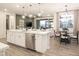 Open-concept kitchen flowing into the dining and living areas, featuring stainless appliances and a large island at 19022 W Rose Ln, Waddell, AZ 85355