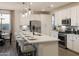 Contemporary kitchen featuring a large island with seating, stainless steel appliances, and pendant lights at 19022 W Rose Ln, Waddell, AZ 85355