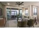 Cozy living room featuring a ceiling fan, comfortable seating, and sliding glass doors to an outdoor patio at 19022 W Rose Ln, Waddell, AZ 85355