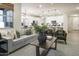 Spacious living room featuring a cozy seating area, a view of the kitchen, and modern interior design at 19022 W Rose Ln, Waddell, AZ 85355