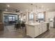 Open living space with a kitchen island, adjacent living room, and sliding glass doors leading to the patio at 19022 W Rose Ln, Waddell, AZ 85355