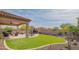 Expansive backyard features covered patio, outdoor fireplace, lush artificial turf, and low-maintenance landscape at 1904 N Steele --, Mesa, AZ 85207