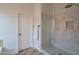 White tiled walk-in shower featuring a glass door, gold hardware, and a niche for storage at 1904 N Steele --, Mesa, AZ 85207