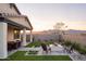 Beautiful backyard with outdoor dining and a fire pit creating the perfect space for relaxation and entertaining friends at 19045 W Rose Ln, Waddell, AZ 85355