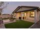 Charming backyard with a fire pit, outdoor dining area, and artificial turf at 19045 W Rose Ln, Waddell, AZ 85355