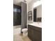 Bathroom features a sleek, black tiled shower and a modern vanity with double sinks, and a framed art piece at 19045 W Rose Ln, Waddell, AZ 85355