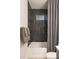 Bathroom features a stylish shower with black tile and a window for natural light; plush towels add comfort at 19045 W Rose Ln, Waddell, AZ 85355