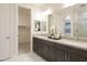 Elegant bathroom with a double vanity, modern fixtures, and a spacious walk-in closet at 19045 W Rose Ln, Waddell, AZ 85355