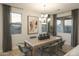 Elegant dining room with a modern chandelier, large windows, and contemporary decor at 19045 W Rose Ln, Waddell, AZ 85355