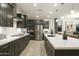 Well-lit kitchen features stainless steel appliances, dark cabinets, and a large island for meal preparation and entertaining at 19045 W Rose Ln, Waddell, AZ 85355