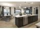 Open-concept kitchen featuring a large island with bar seating adjacent to the dining and living areas at 19045 W Rose Ln, Waddell, AZ 85355