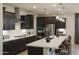 A modern kitchen with dark wood cabinets, stainless steel appliances, and a large island with seating at 19045 W Rose Ln, Waddell, AZ 85355