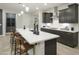 A bright kitchen with dark cabinets, a white backsplash, and a large island with a breakfast bar at 19045 W Rose Ln, Waddell, AZ 85355