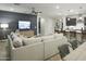 Open-concept living space with a cozy sectional sofa, modern entertainment center, and easy access to the kitchen at 19045 W Rose Ln, Waddell, AZ 85355