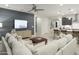 Open-concept living room with a modern entertainment center and seamless flow to the kitchen at 19045 W Rose Ln, Waddell, AZ 85355