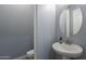 Powder room with a modern sink, a round mirror, and a neutral color scheme at 21617 S 229Th Way, Queen Creek, AZ 85142