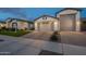 Charming home featuring a three-car garage, a brick paver driveway, and lush landscaping at 21617 S 229Th Way, Queen Creek, AZ 85142