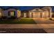 Inviting front exterior showcasing a well-manicured lawn, three-car garage, and stone details at 21617 S 229Th Way, Queen Creek, AZ 85142