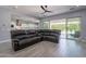 Open-concept living room featuring a large sectional sofa, tile floors, and sliding glass doors at 21617 S 229Th Way, Queen Creek, AZ 85142